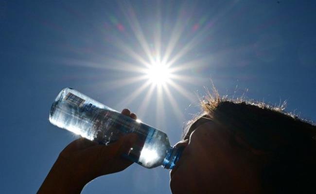 A child sips water from a bottle under a scorching sun on August 30, 2022 in Los Angeles, California. (AFP)