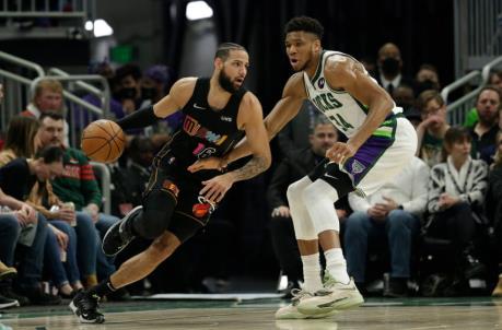 Caleb Martin #16 of the Miami Heat dribbles while being guarded by Giannis Antetokounmpo #34 of the Milwaukee Bucks
(Photo by John Fisher/Getty Images)